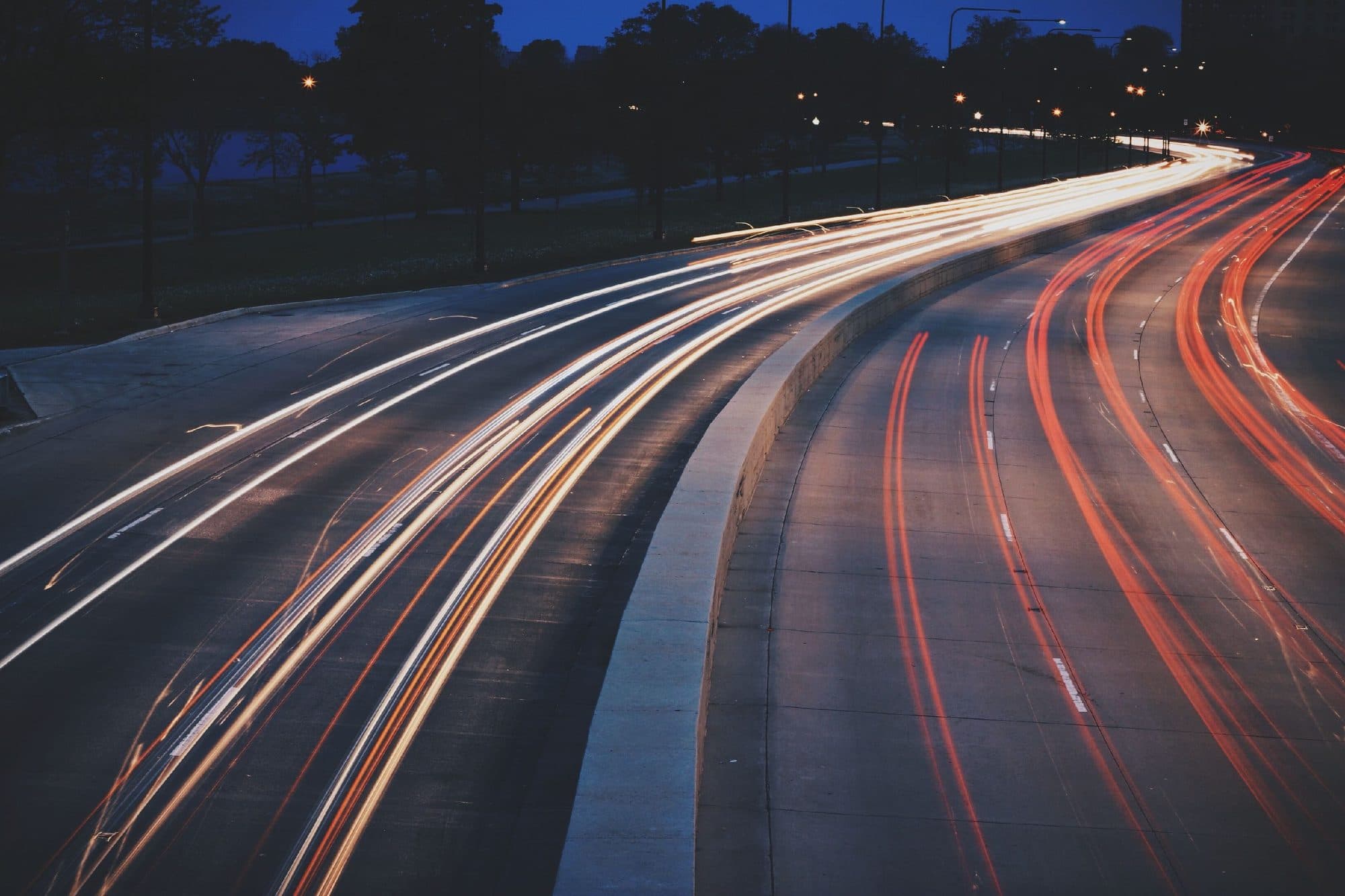 Autopista de noche con estelas de luz de los vehículos en movimiento